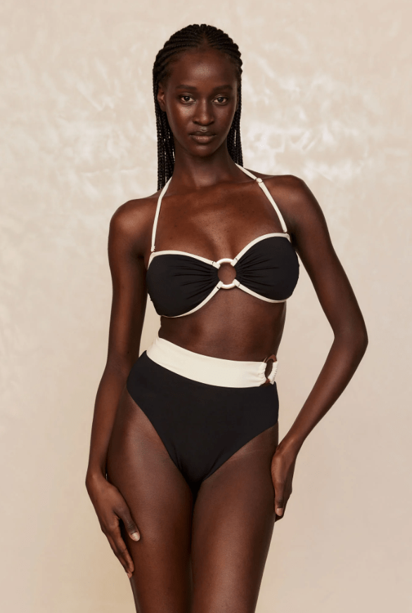 Model wears black bikini with matching bottoms and white trim