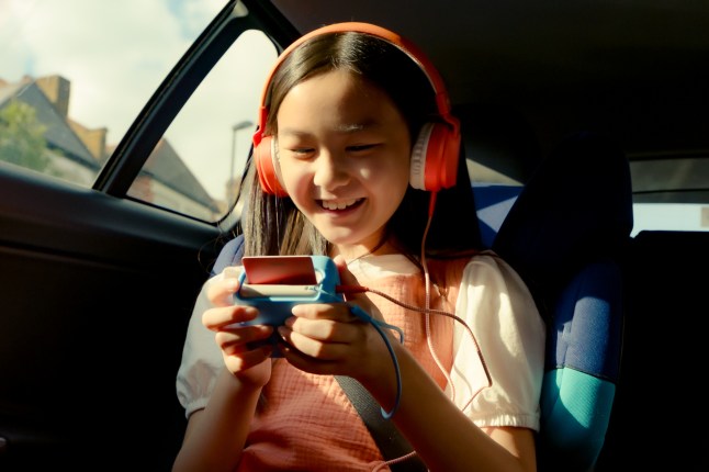 Child in a car, listening to a small device
