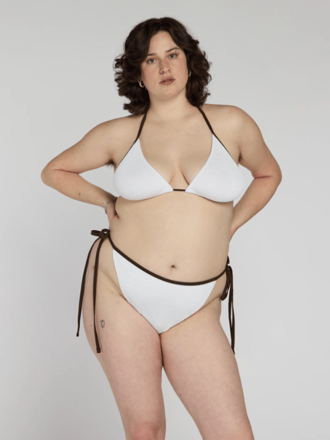 Female wears white bikini with black trim
